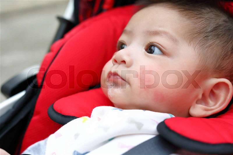 Cute baby boy happy playful bubbles saliva drool on child mouth with allergic rash on kid chubby cheeks, stock photo