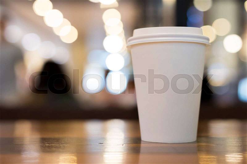 Take away coffee cup empty blank copy space for your design text or banner of brand, hot drink on wood table in cafe shop restaurant with beautiful light decoration, image used retro vintage filter, stock photo