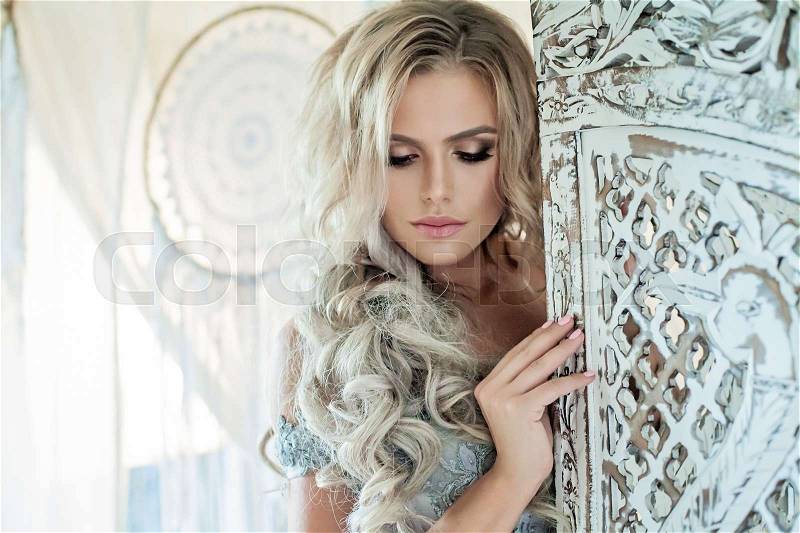 Beautiful Woman Fashion Model with Blonde Curly Hairstyle in Vintage Interior Background, stock photo