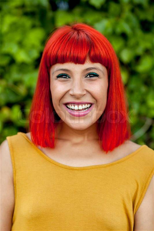 Happy red hair woman with yellow dress in a park, stock photo