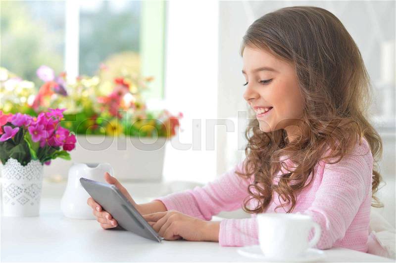 Portrait of Beautiful little girl with tablet pc, stock photo