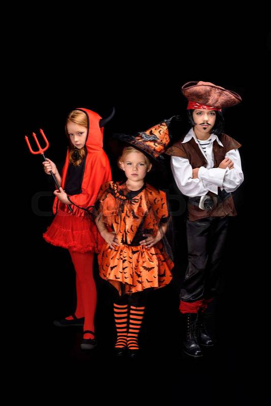 Kids in halloween costumes of devil, witch and pirate posing isolated on black , stock photo