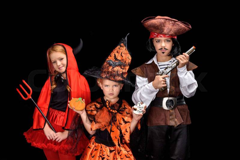 Kids in halloween costumes of devil, witch and pirate posing isolated on black, stock photo
