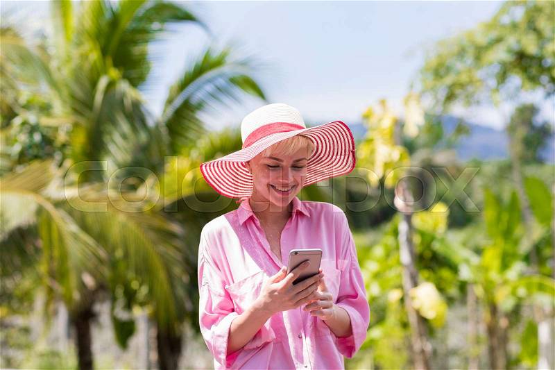 Young Woman Messaging With Cell Smart Phone Over Tropical Forest And Blue Sky Pretty Girl Chatting Online Social Media Communication Concept, stock photo