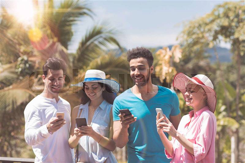 Happy Group Of Young People Messaging With Cell Smart Phones Outdoors On Summer Terrace With Tropical Forest View Mix Race Men And Women Social Media Communication Concept, stock photo
