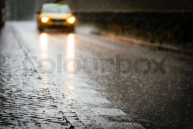 Taxi circulating on wet asphalt while its raining. Rain Concept, stock photo