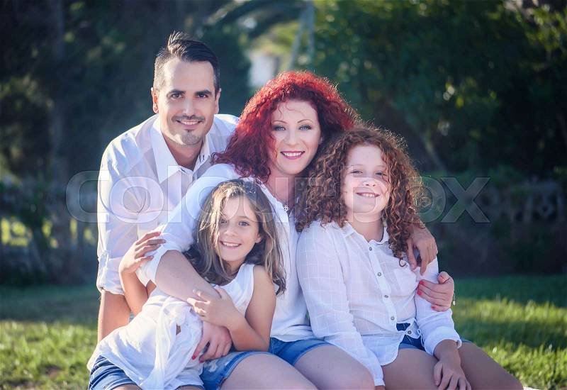 Happy family mum, rpapa and two daughters against nature background, stock photo