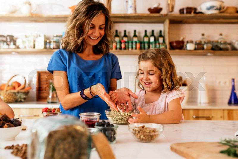 Little sisters cooking with her mother in the kitchen. Infant Chef Concept, stock photo