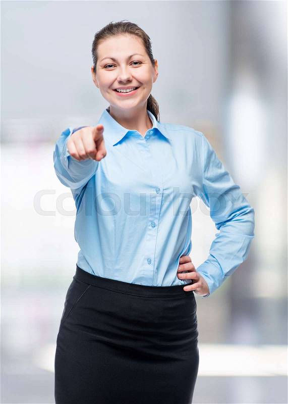 Young brunette woman in a blue shirt chooses you!, stock photo