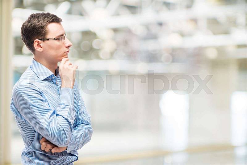 Businessman pondering business strategy, portrait in office, stock photo