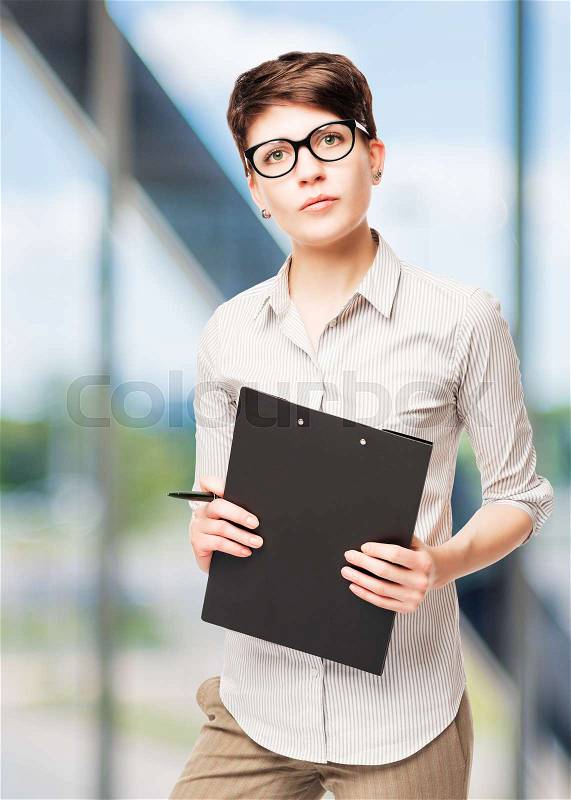 Vertical portrait of a 25 year old business woman with a folder in the office, stock photo
