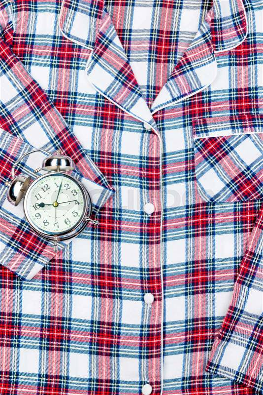 Classic checkered pajamas in full frame and a retro alarm clock, stock photo