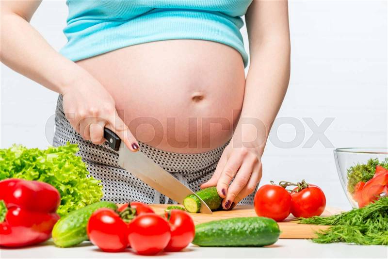 Future mother and healthy food, hands prepare vegetable salad, stock photo