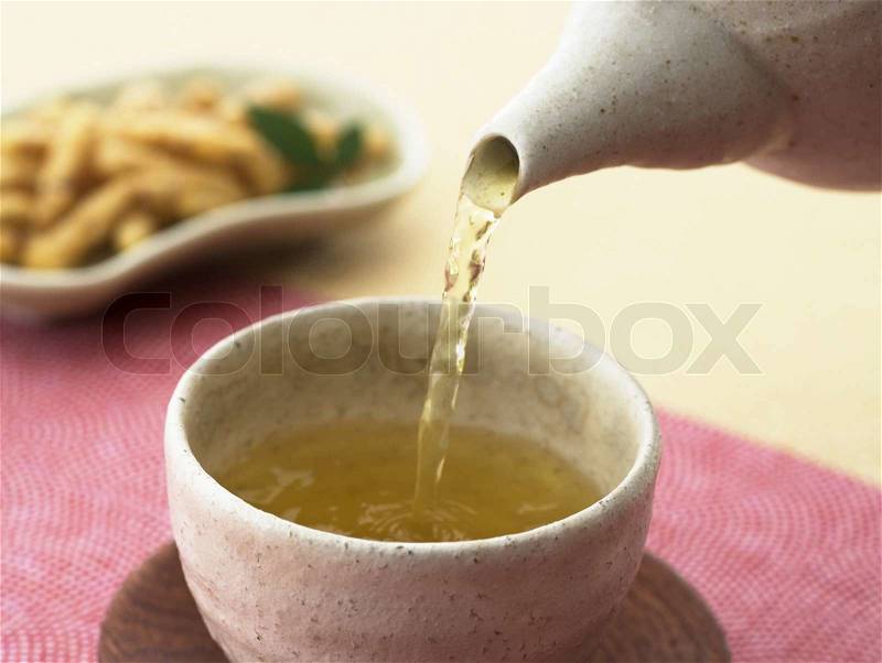 Cup of green tea pouring close up shoot, stock photo