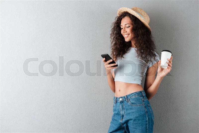 Young pretty woman with coffee chatting on smartphone isolated, stock photo