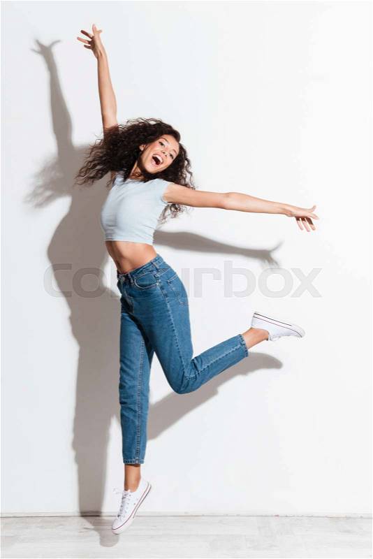 Full-length shot happy woman jumping isolated with smile, stock photo