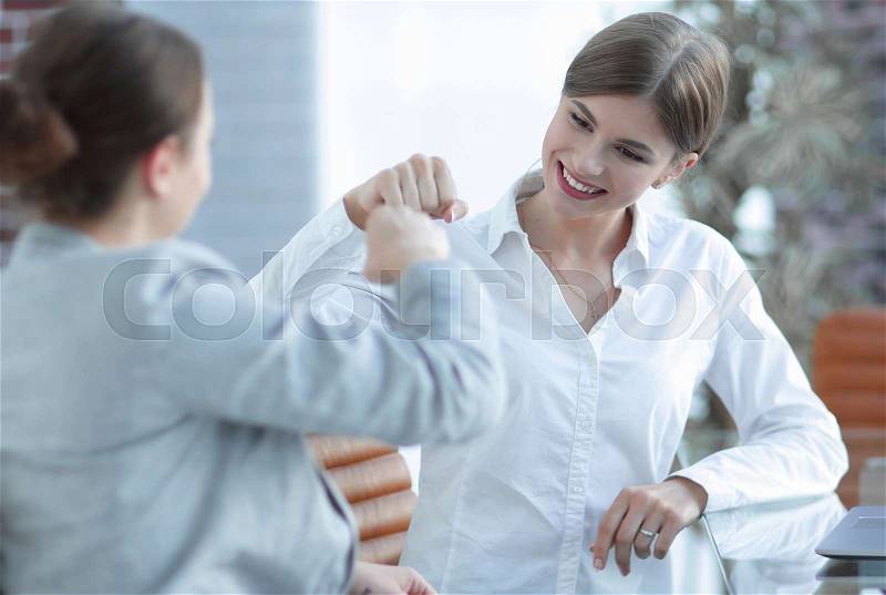 Happy employees are happy with the obtained results and give each other a fist bump, stock photo