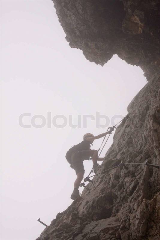 Female climbing ferrata in julian alps, slovenia, stock photo