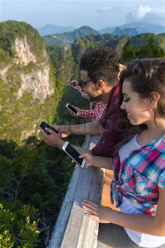 Young People Group In Mountain Using Cell Smart Phone Chatting Online Friends Asian Holiday Summer Vacation Travel, stock photo