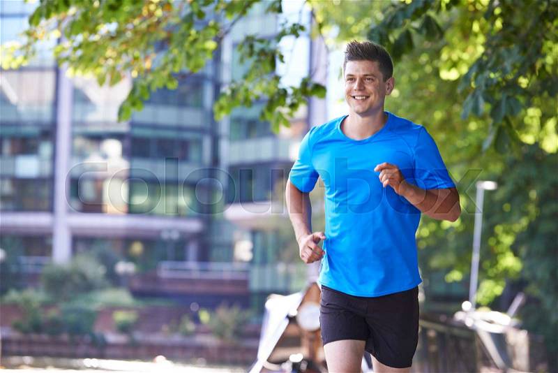 Man Running By River In Urban Setting , stock photo