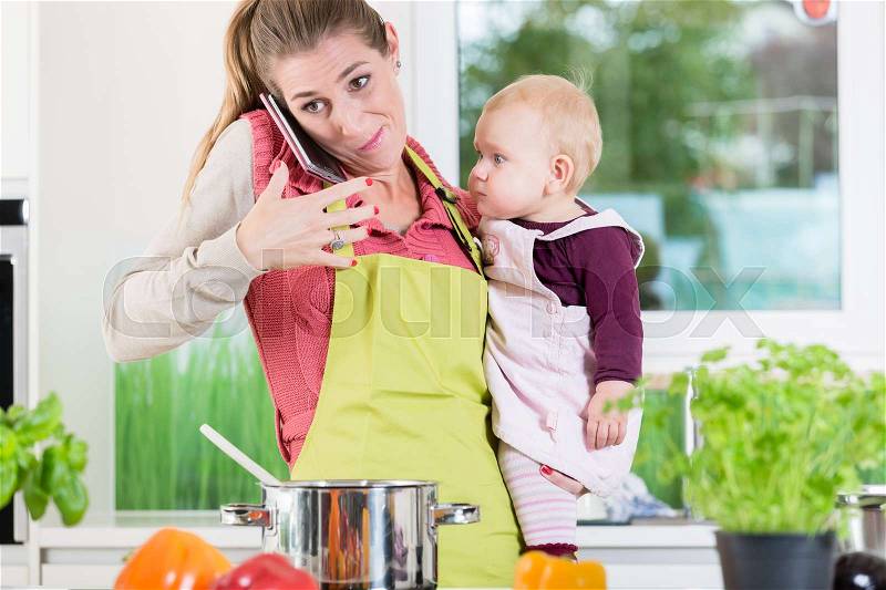 Working mom being stressed by housework, cooking, preparing, job, mobile phone and kids , stock photo