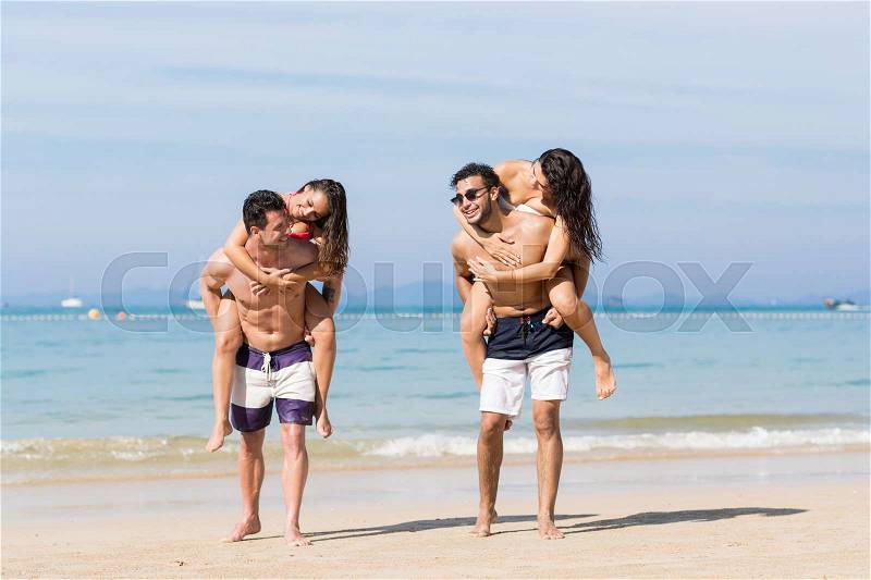 Two Couple On Beach Summer Vacation, Young People Happy Smiling, Man Carry Woman Sea Ocean Holiday Travel, stock photo