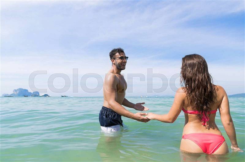 Couple On Beach Summer Vacation, Young People In Water , Man Woman Holding Hands Sea Ocean Holiday Travel, stock photo