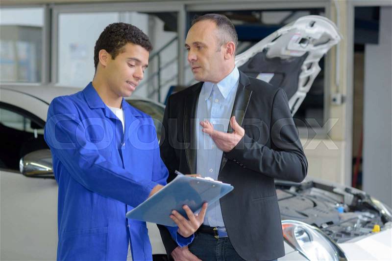 Mechanic and client in car service, stock photo