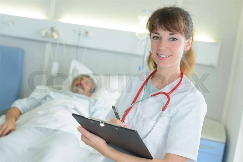 Portrait of nurse holding file in hospital room, stock photo