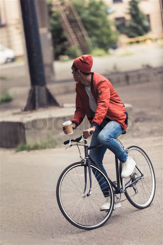 Stylish man riding vintage bicycle and coffee to go, stock photo