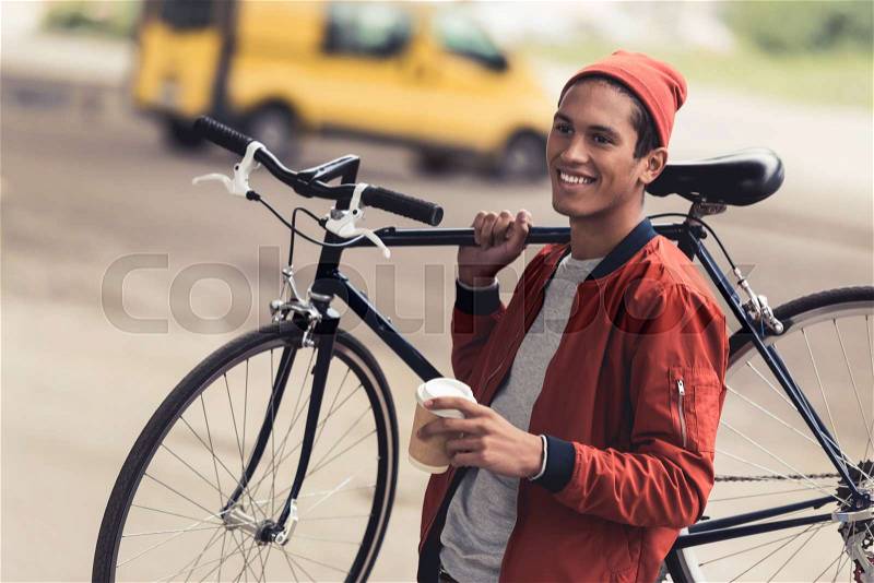 Happy stylish man with vintage bicycle and coffee to go, stock photo