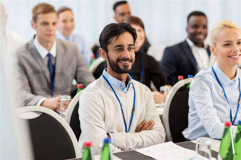 Business and education concept - group of happy people at international conference, stock photo