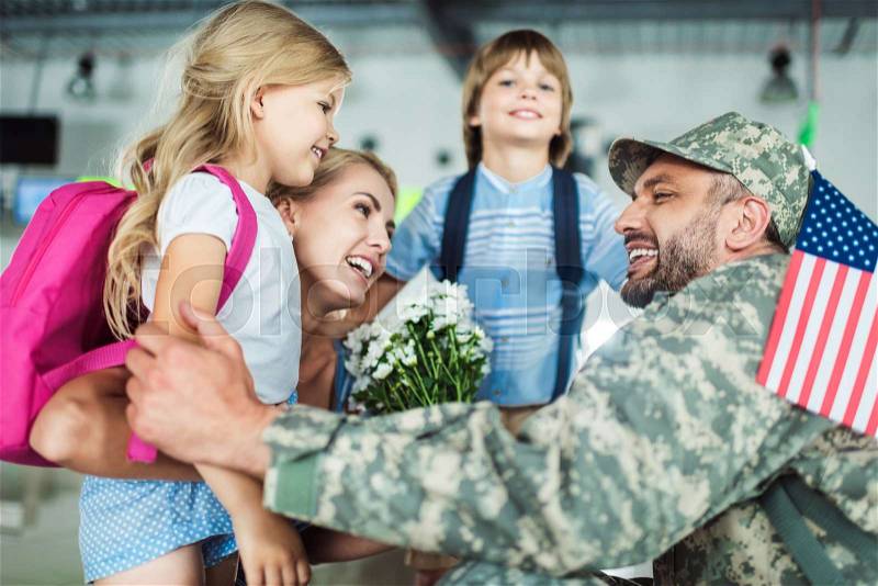 Portrait of happy family and man in military uniform at airport, stock photo