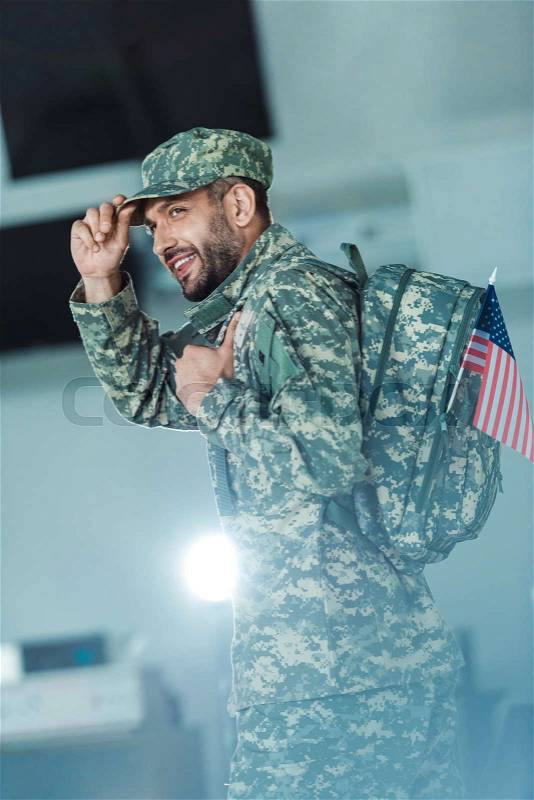 Side view of smiling soldier in military form walking at airport , stock photo