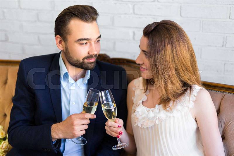 Dating concept - young beautiful couple drinking champagne at home, stock photo