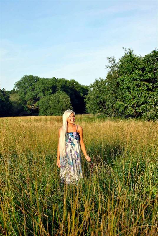 Blonde girl alone in field. Freedom, stock photo