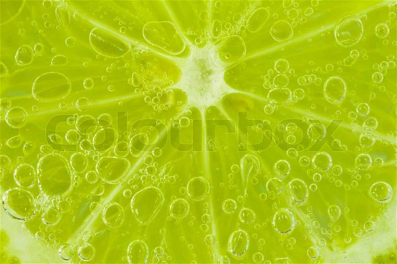 Slice of lime in the water with bubbles, stock photo