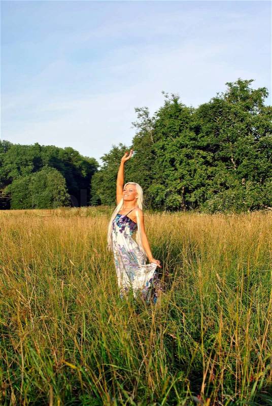 Blonde girl alone in field. Freedom, stock photo