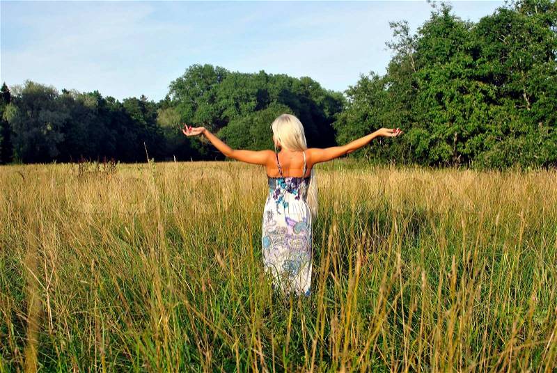 Blonde girl alone in field From the back Freedom, stock photo