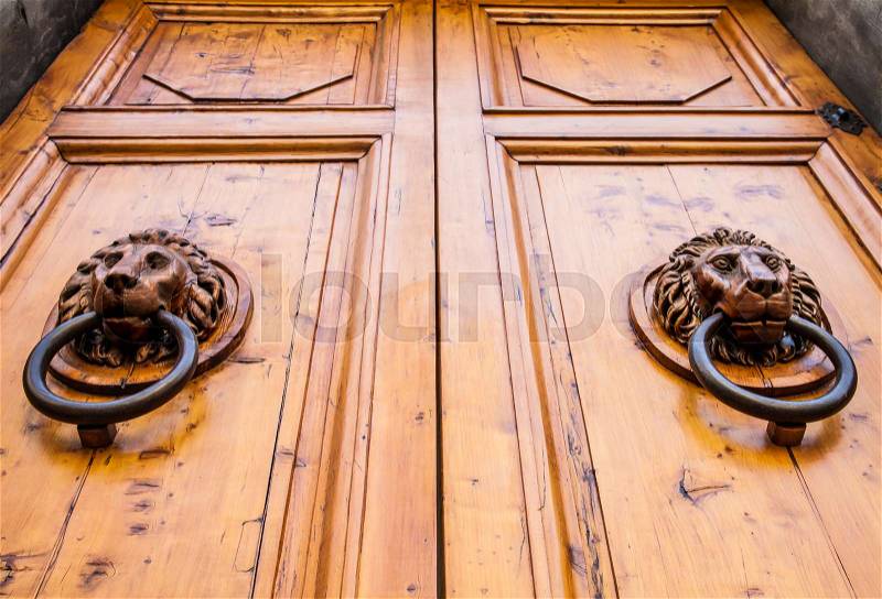 Lion head knocker on an old wooden door in Tuscany - Italy, stock photo
