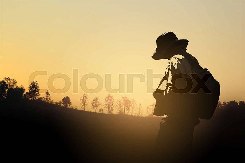 Silhouette Of Camera Man Standing At Forest In Sunset, stock photo