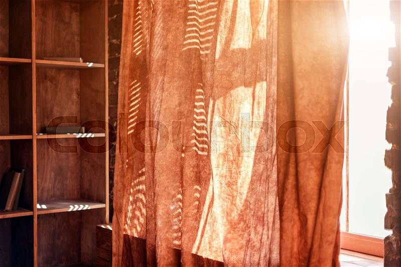 Sunlight from outside window streams into a room through curtains, stock photo