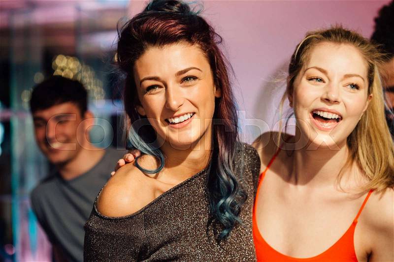 Happy women are dancing together in a nightclub, stock photo