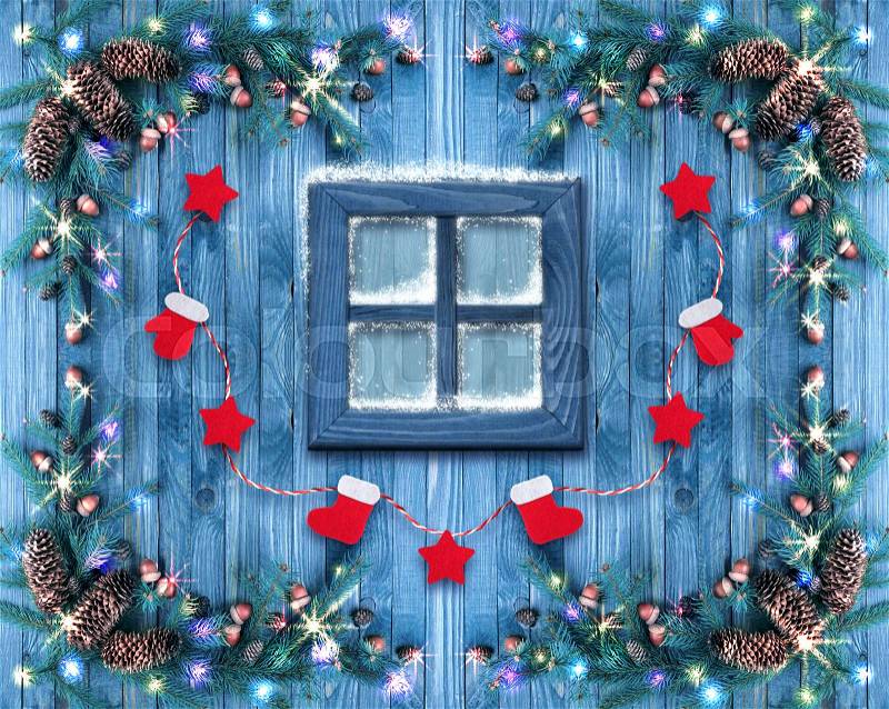 Christmas wooden window decorated with New Year decor in rustic vintage style with light illumination, snow and spruce. Winter holidays concept, stock photo