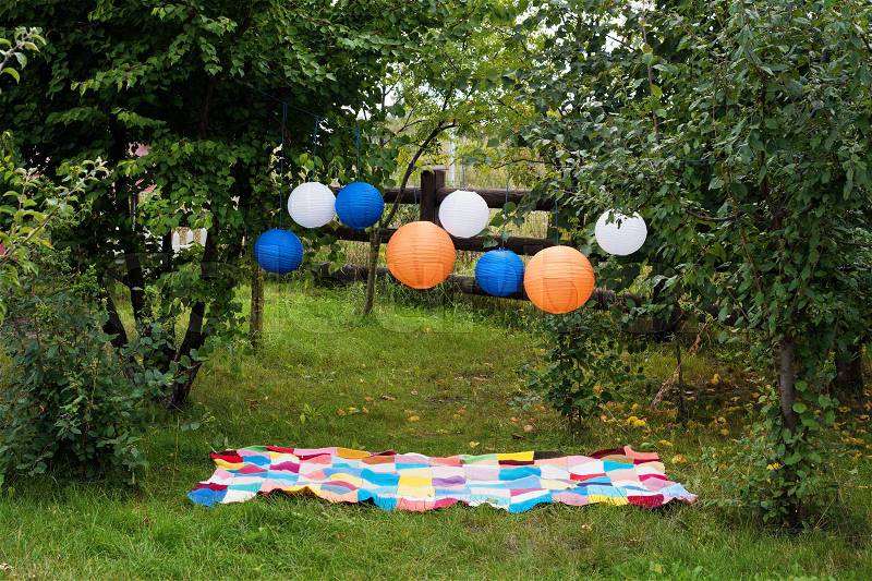 Picnic setting outdoors with plaid and paper lanterns. Celebration, party concept, romance, love date theme, stock photo