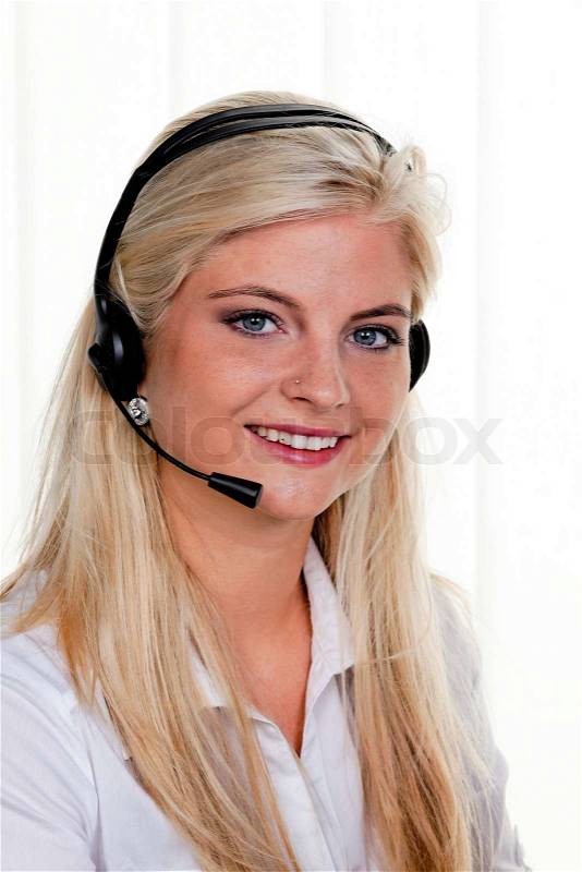 Young woman with telephone headset in a call center, stock photo