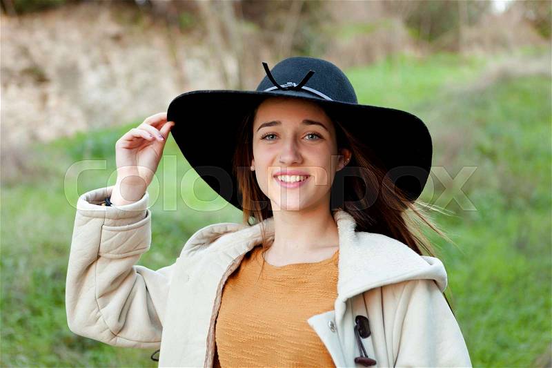 Stylish young woman with big hat in the field, stock photo