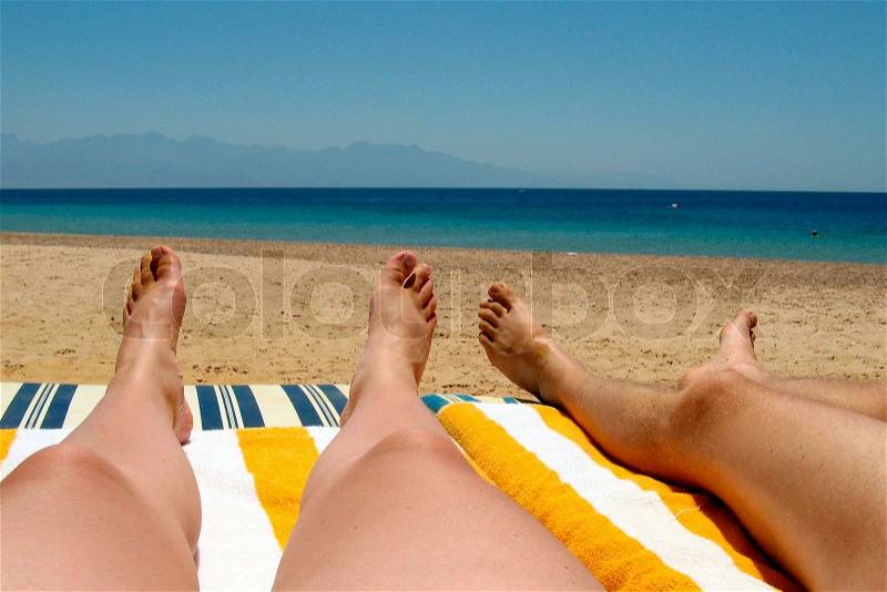Man and wife lounge on the beach near Reds sea, stock photo
