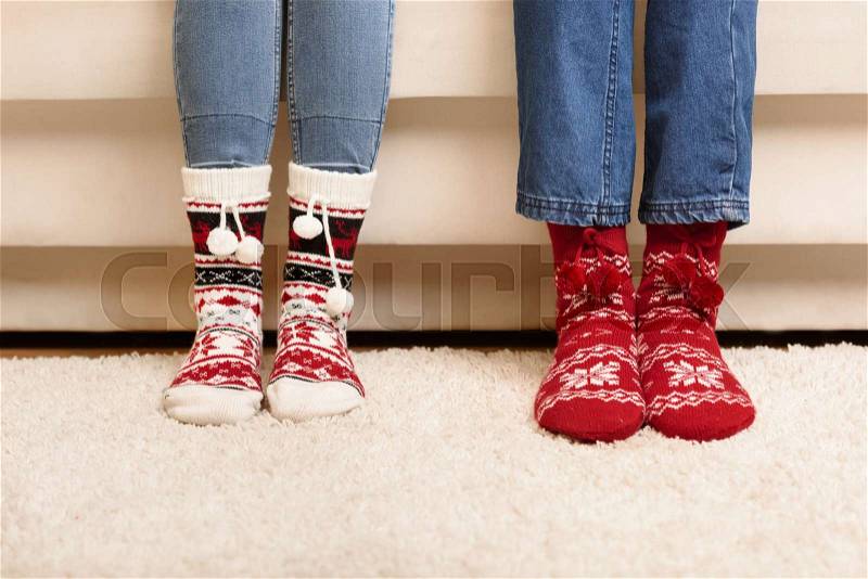 Close-up partial view of feet of couple in knitted socks, stock photo