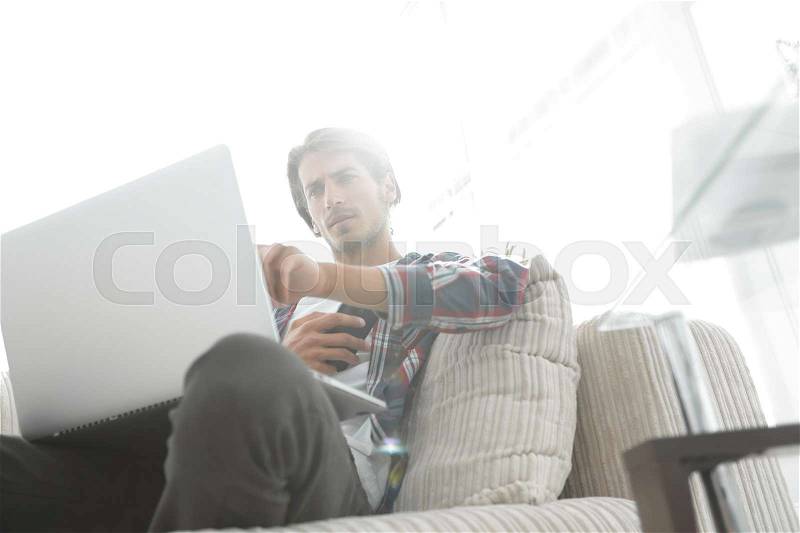 Young guy with smartphone sitting in a chair. on a blurry background. business background , stock photo